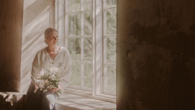 Morsian istuu Juhlatila Valimon ikkunalaudalla kukkakimppu kädessä.