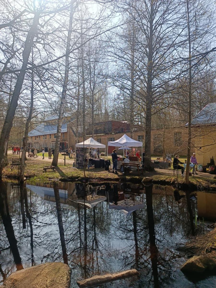 keväinen kuva Mathildedalin ruukkitehtaan rakennuksista, edessä joki