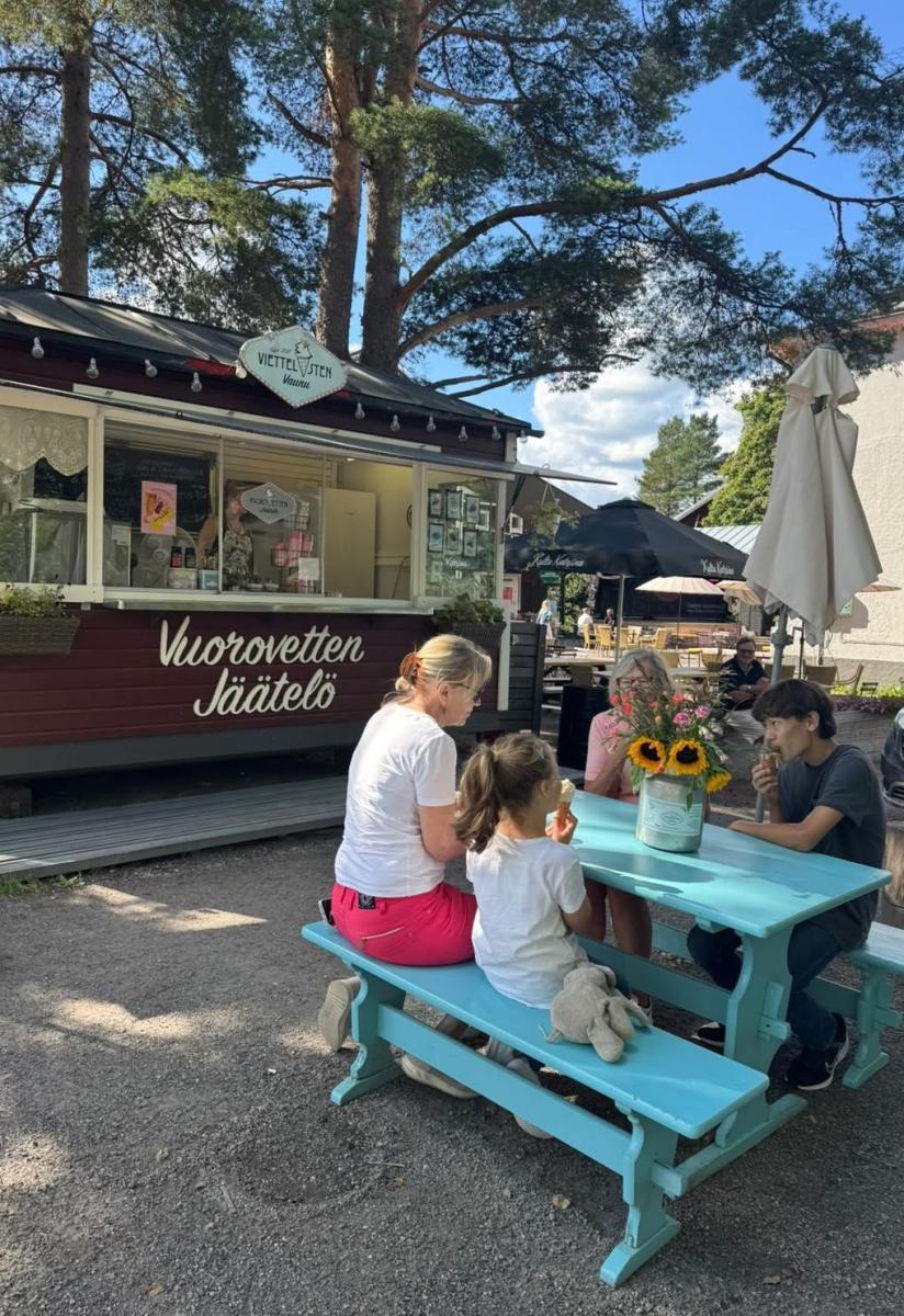 ihmisiä istumassa jäätelökioski viettelysten vaunun edessä